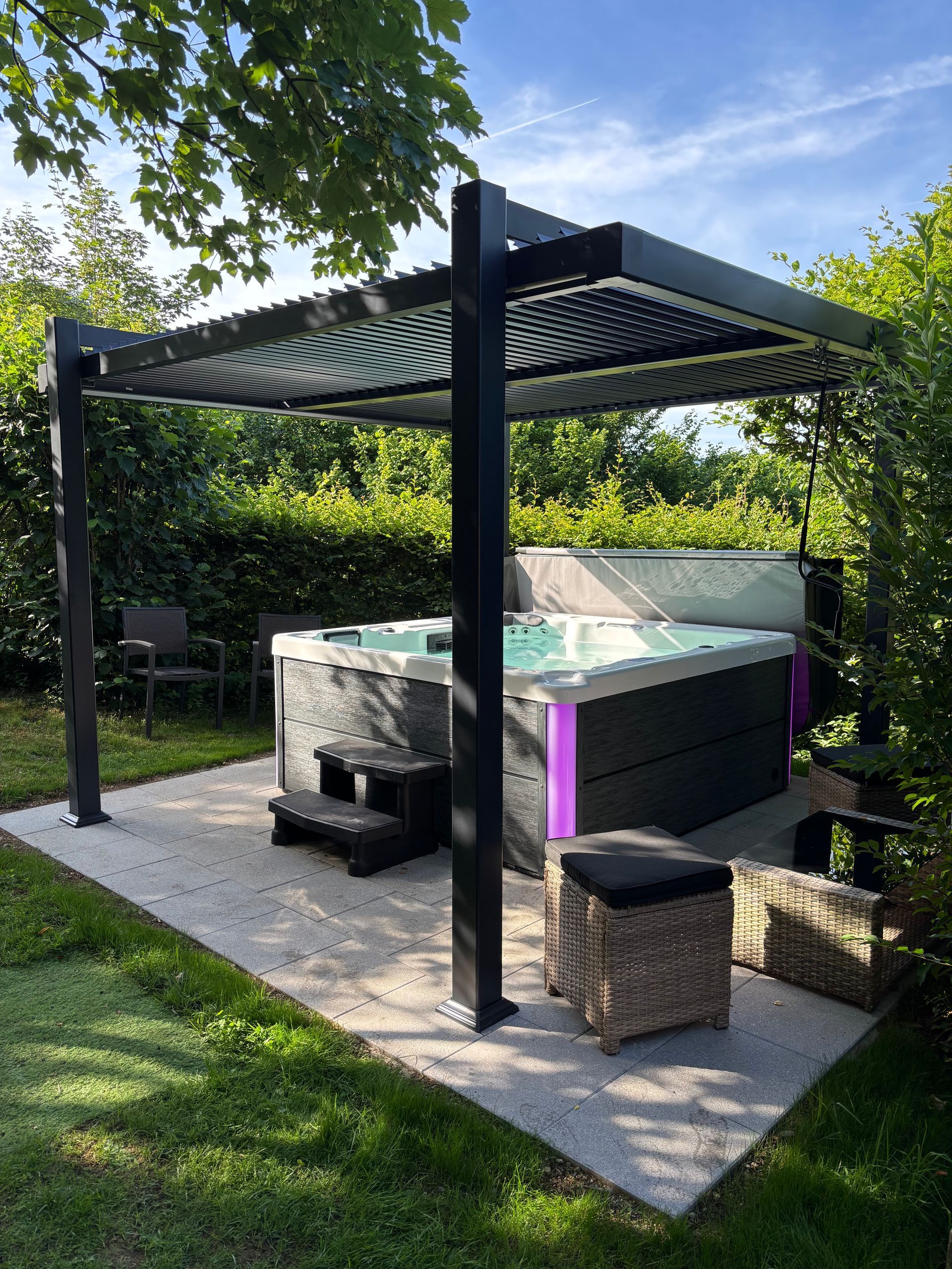 Un bain à remous est installé sous une pergola dans une cour arrière.