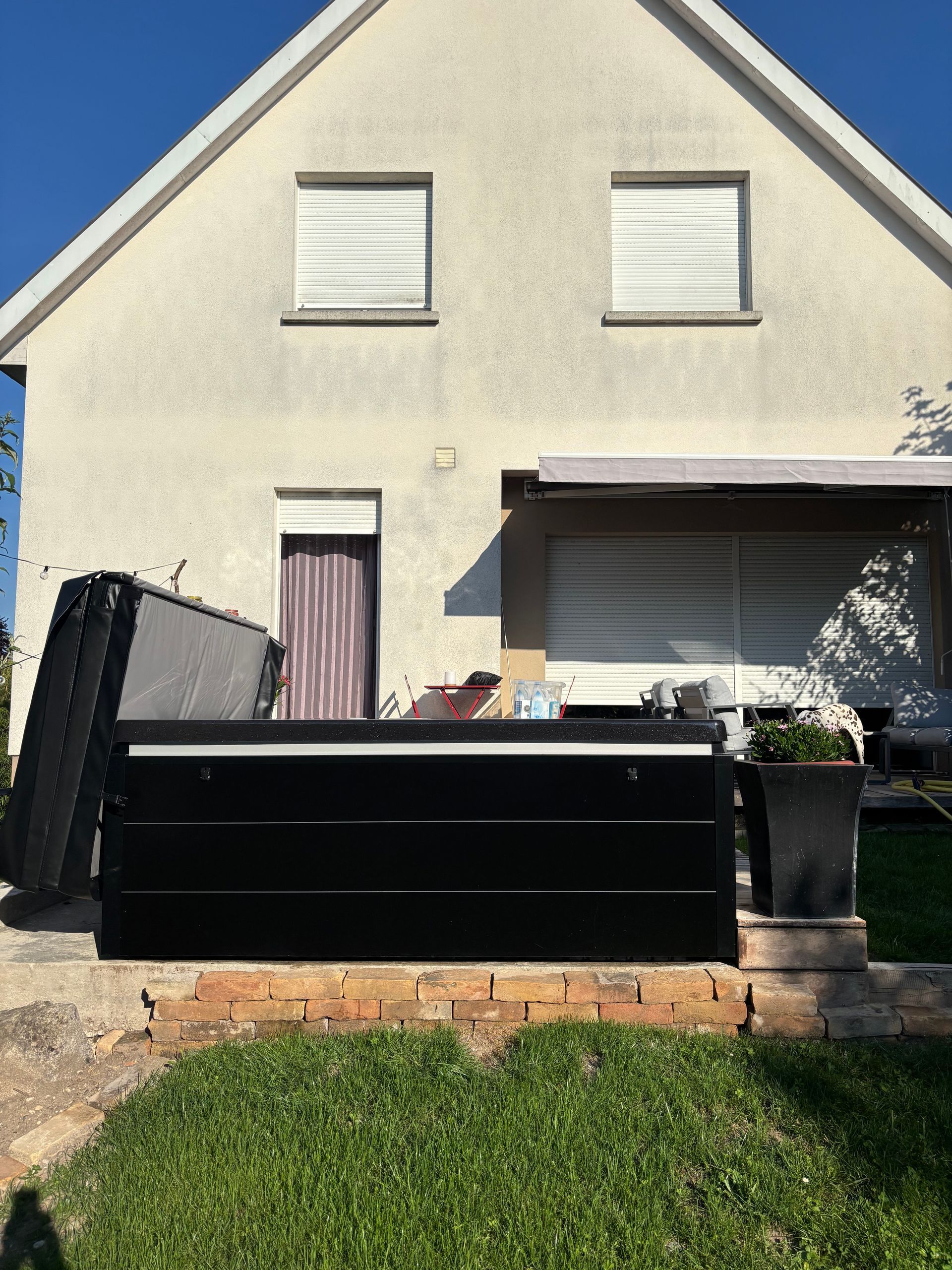 Une maison blanche avec une boîte noire devant elle