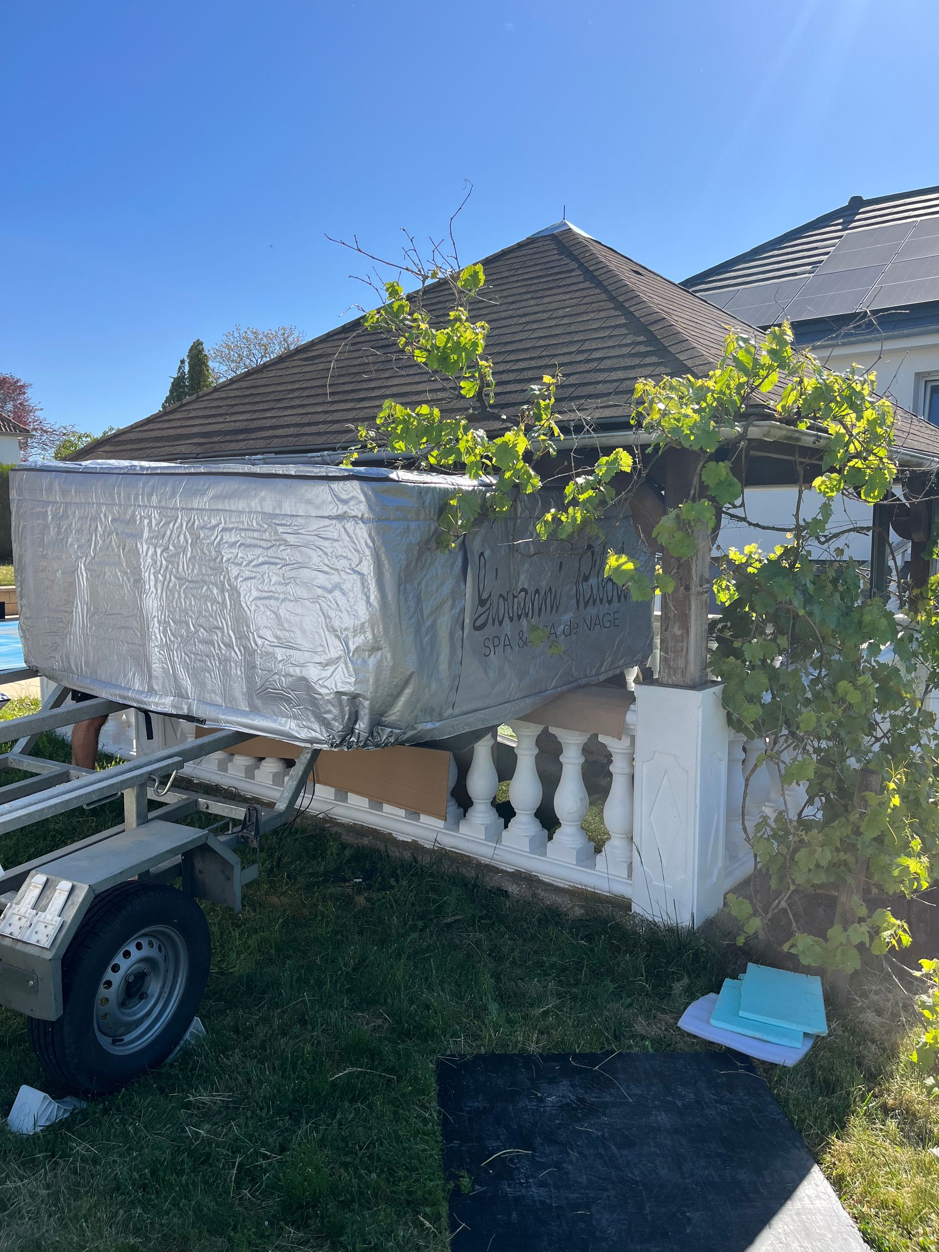 Une remorque est garée devant une maison par une journée ensoleillée.