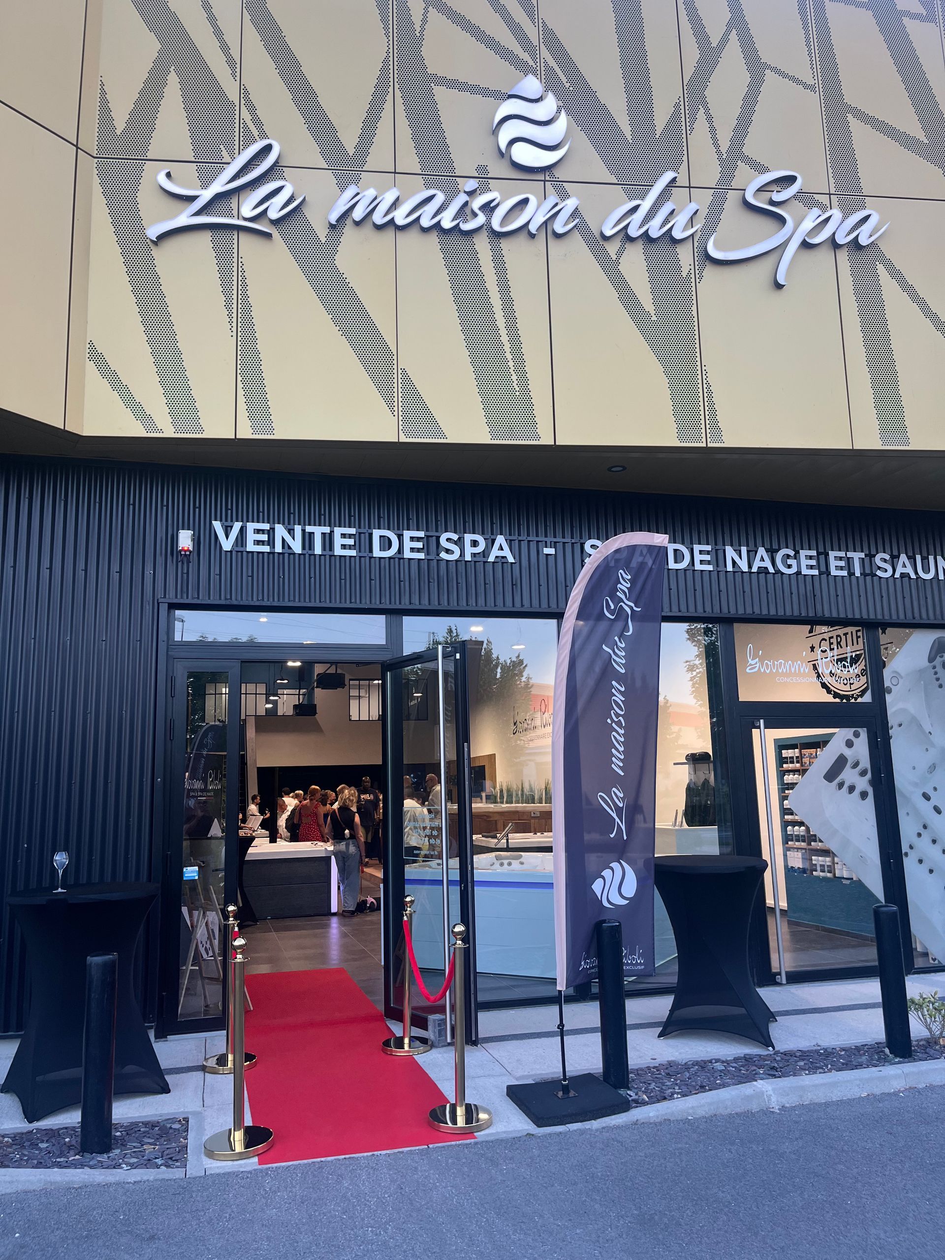 Une devanture de magasin avec un tapis rouge devant.