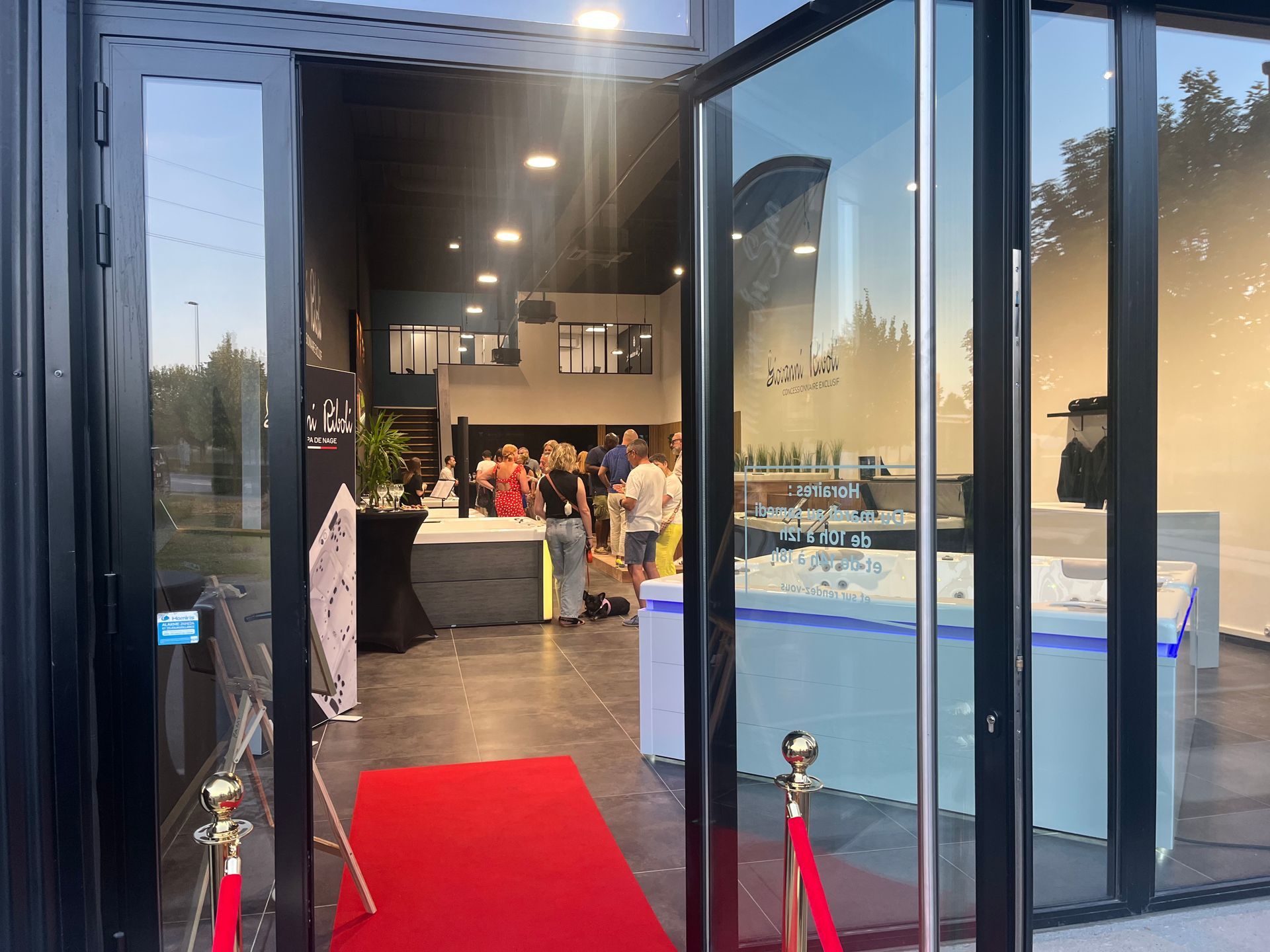 Un groupe de personnes se tient à l'extérieur d'un bâtiment avec un tapis rouge.