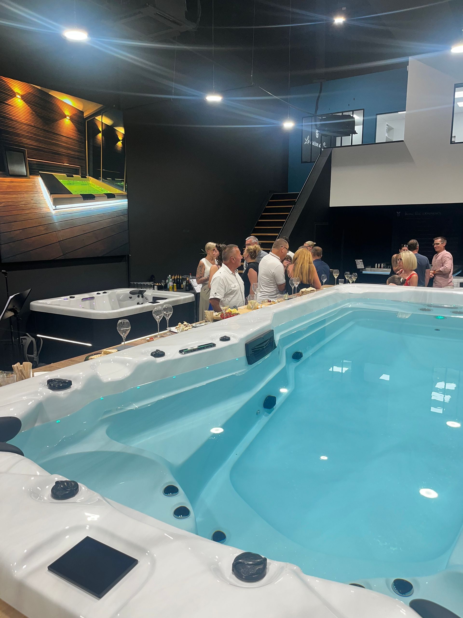 Un groupe de personnes se tient autour d'une grande piscine.