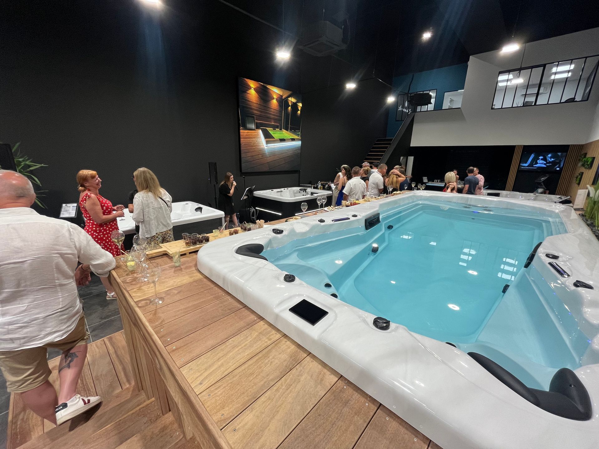 Un groupe de personnes se tient autour d'une grande piscine.