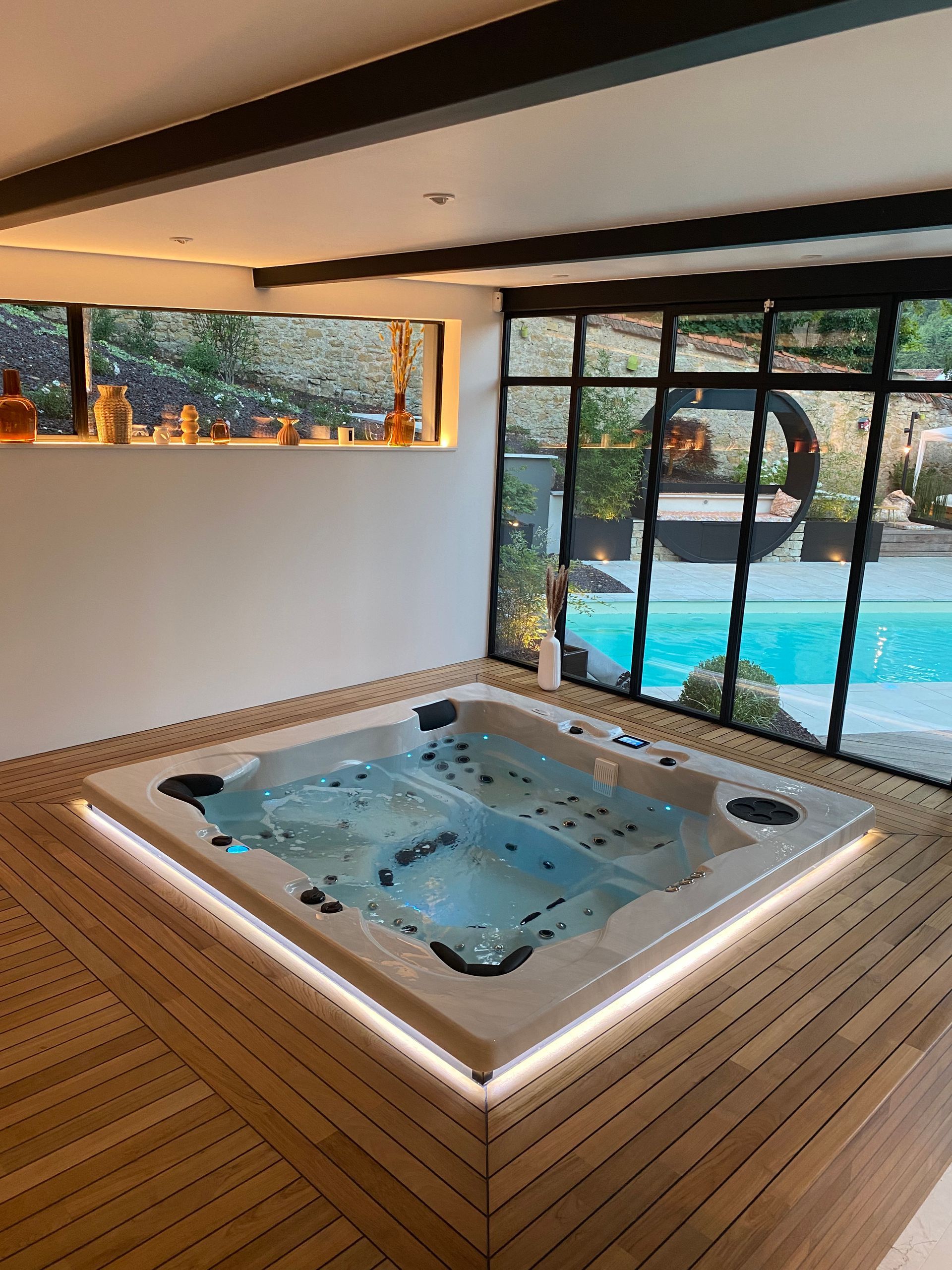 Un grand jacuzzi se trouve dans une pièce à côté d'une piscine.