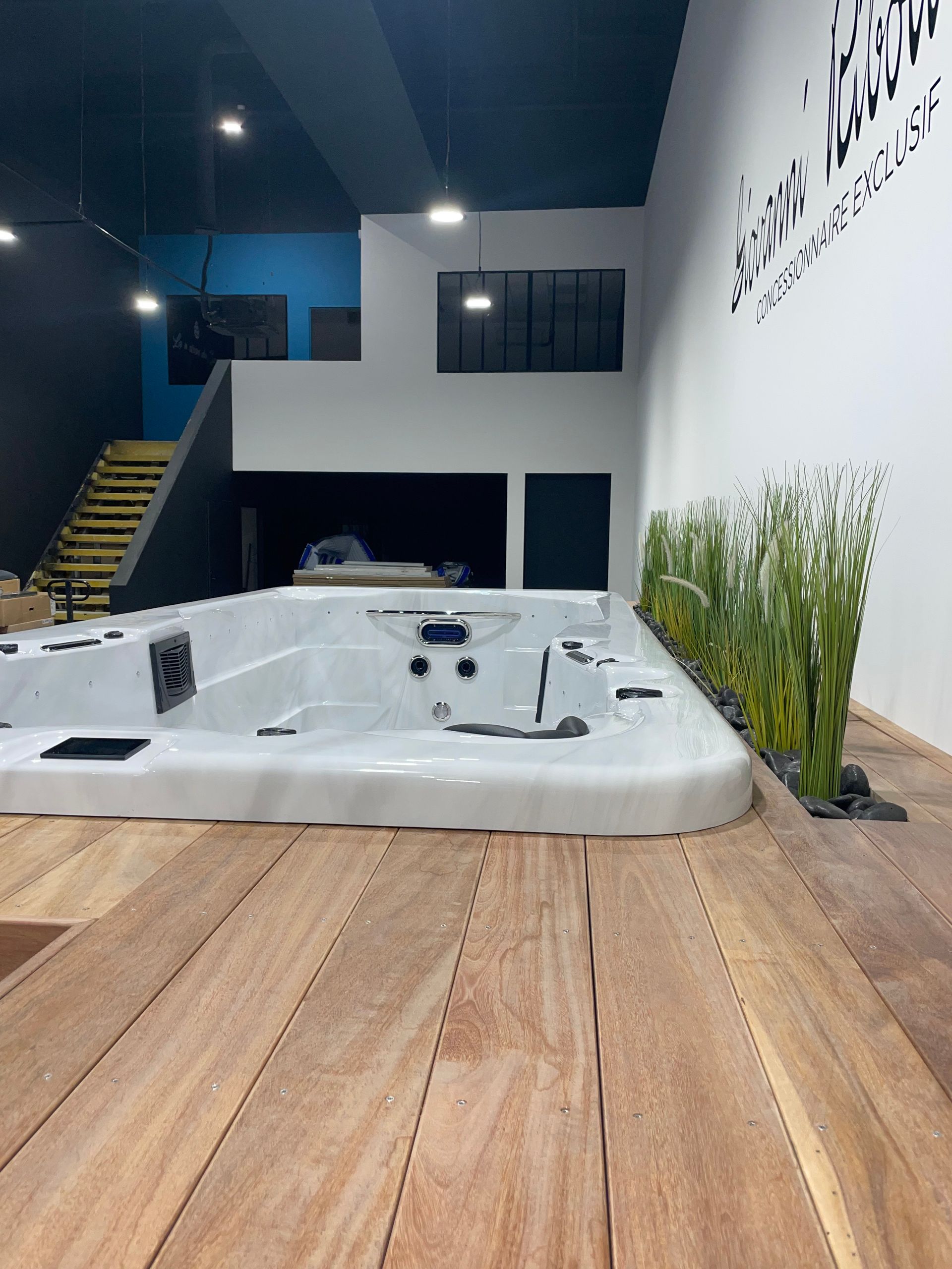 Un bain à remous est posé sur un plancher en bois dans une pièce.