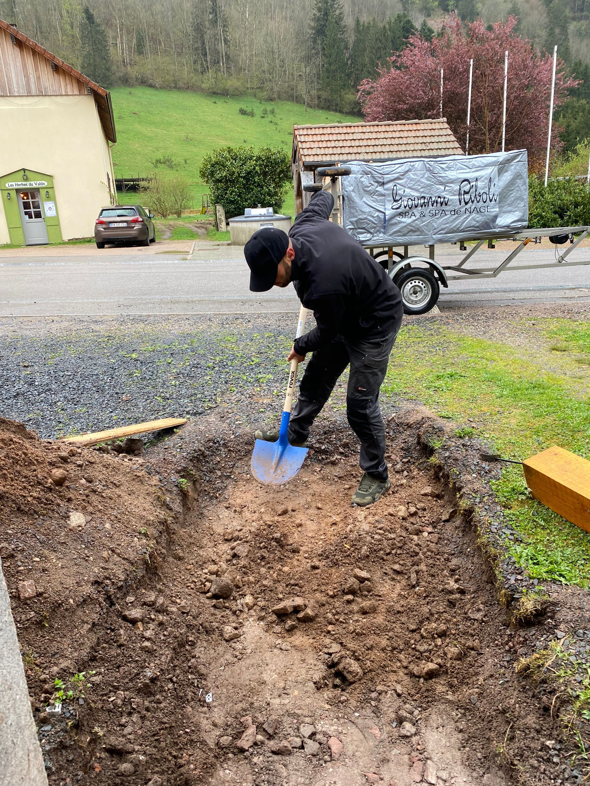 Un homme creuse la terre avec une pelle.