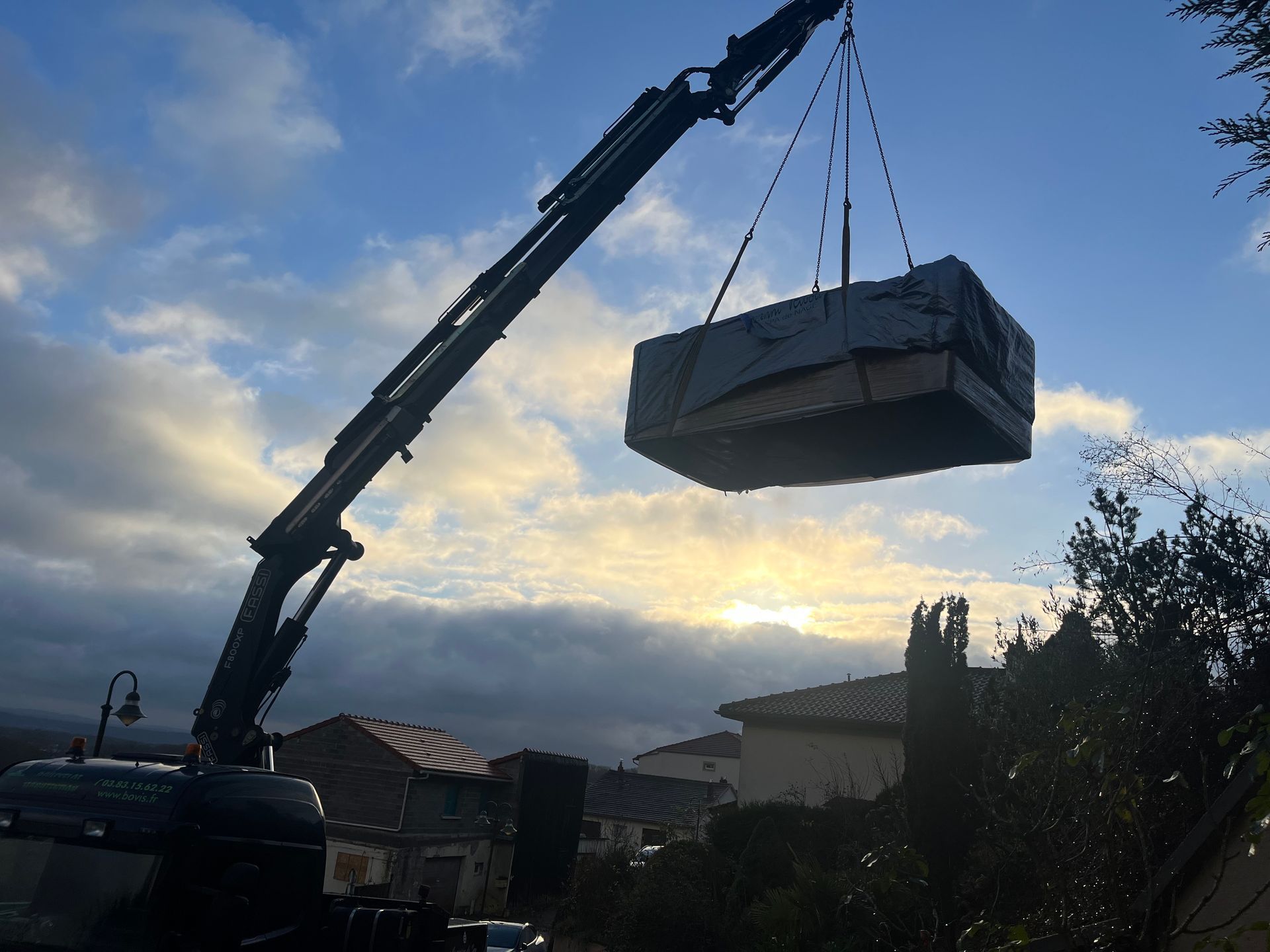 Une grue soulève une grande boîte dans les airs