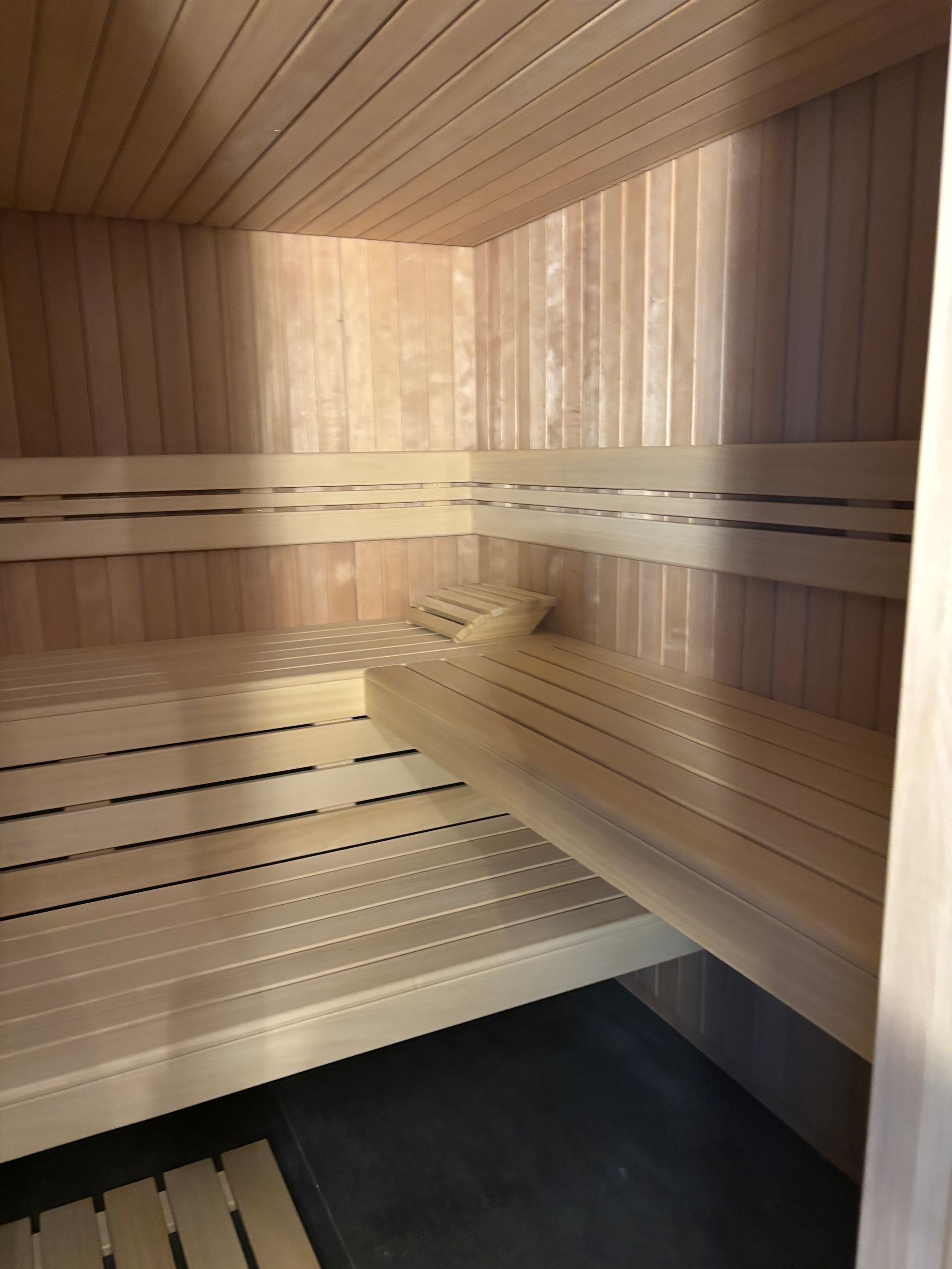 Intérieur d'un sauna en bois avec bancs et plafond.