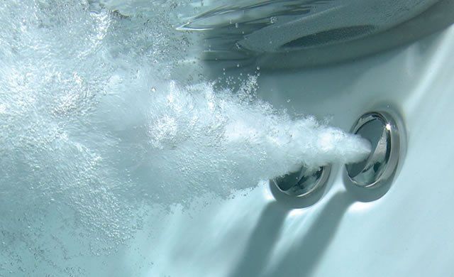 Un gros plan d'un bain à remous avec des bulles qui en sortent.