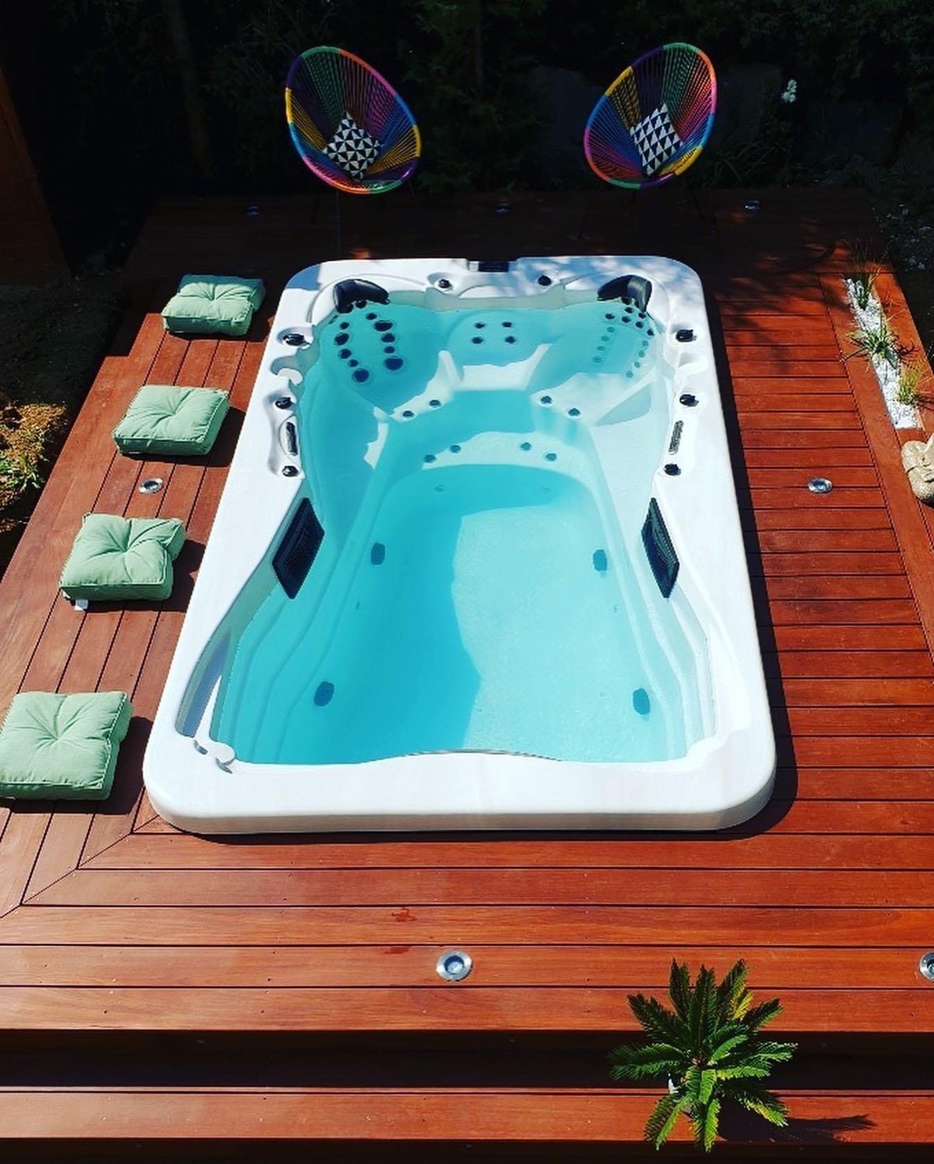 Un bain à remous est posé sur une terrasse en bois.