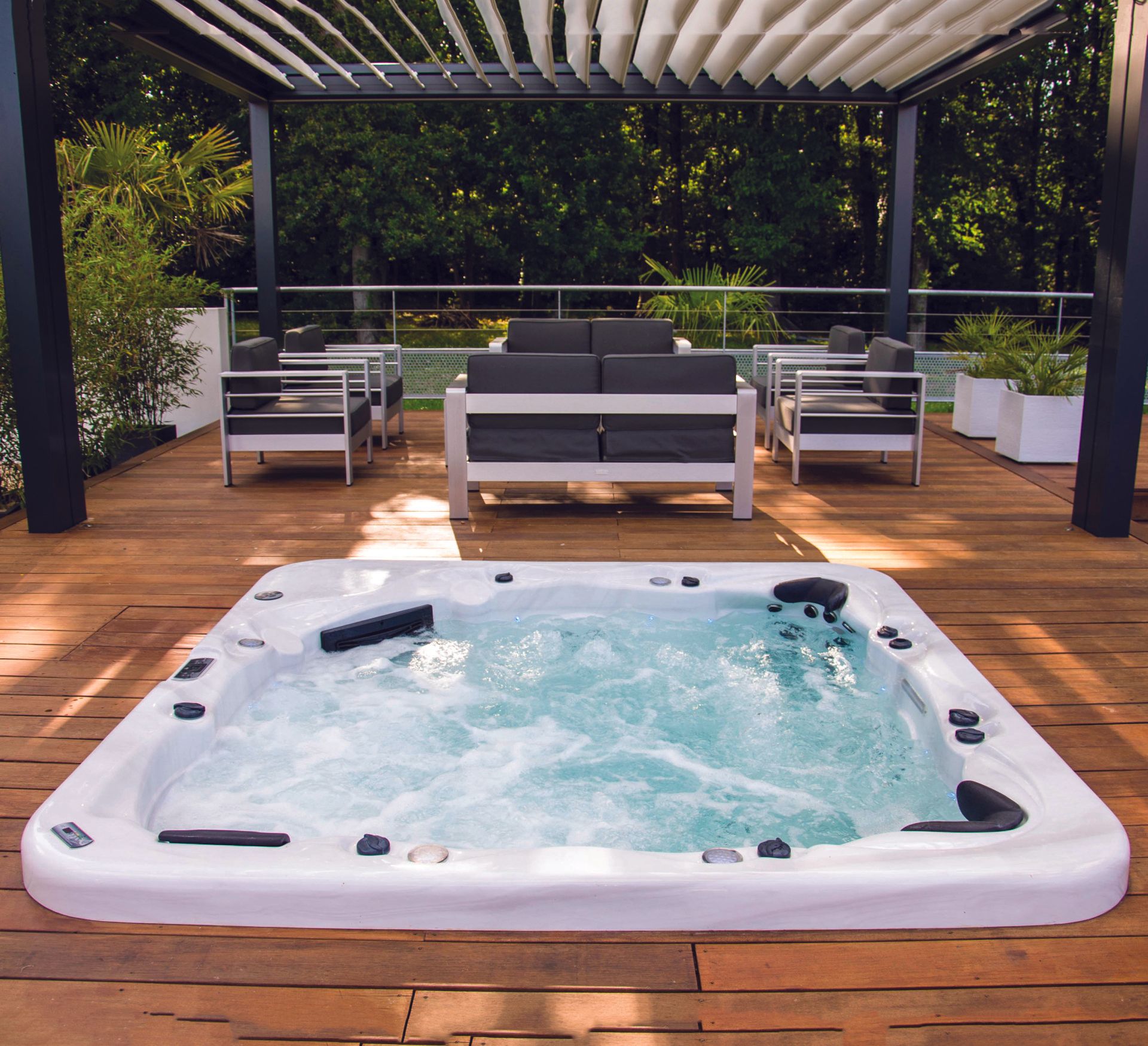 Un bain à remous est sur une terrasse en bois sous une pergola
