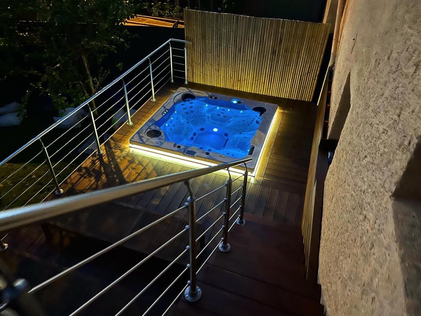 Un bain à remous est posé sur une terrasse à côté d'une balustrade.