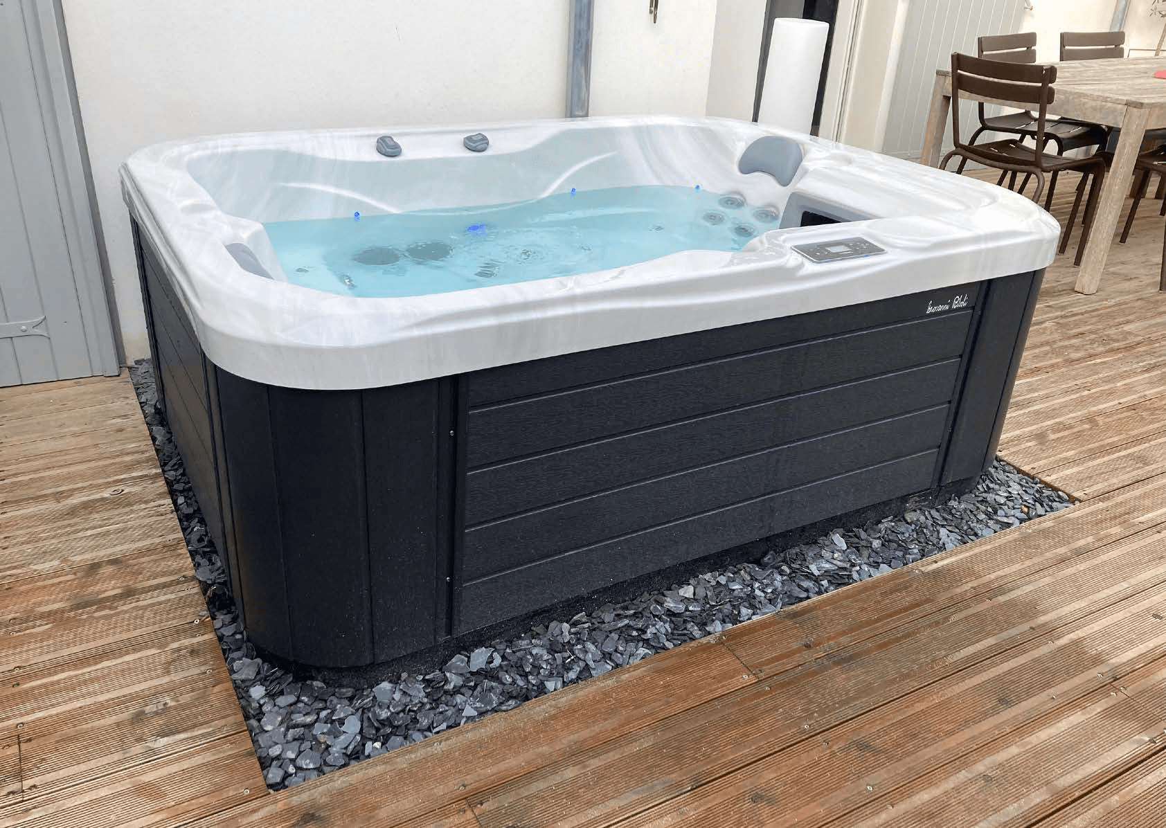 Un bain à remous est posé sur une terrasse en bois.