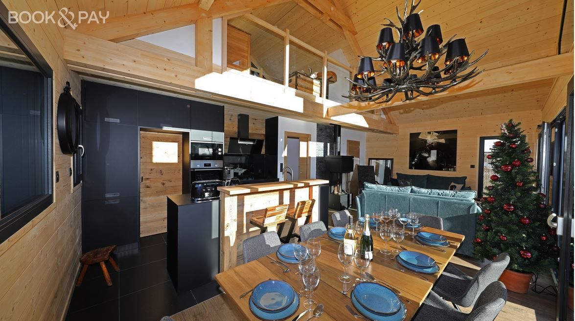 Un salon avec une table à manger et un sapin de Noël