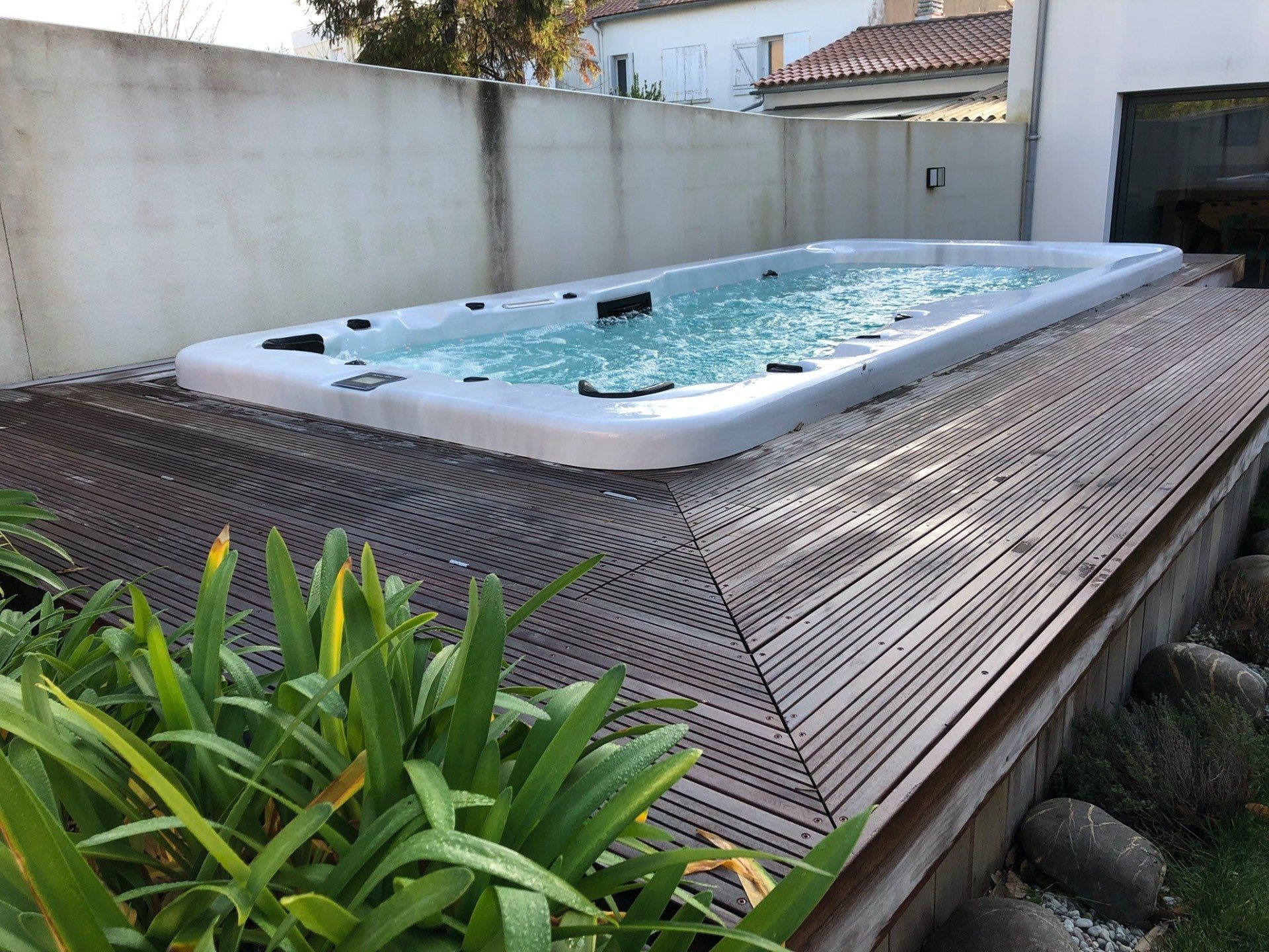 Une grande piscine est située sur une terrasse en bois.