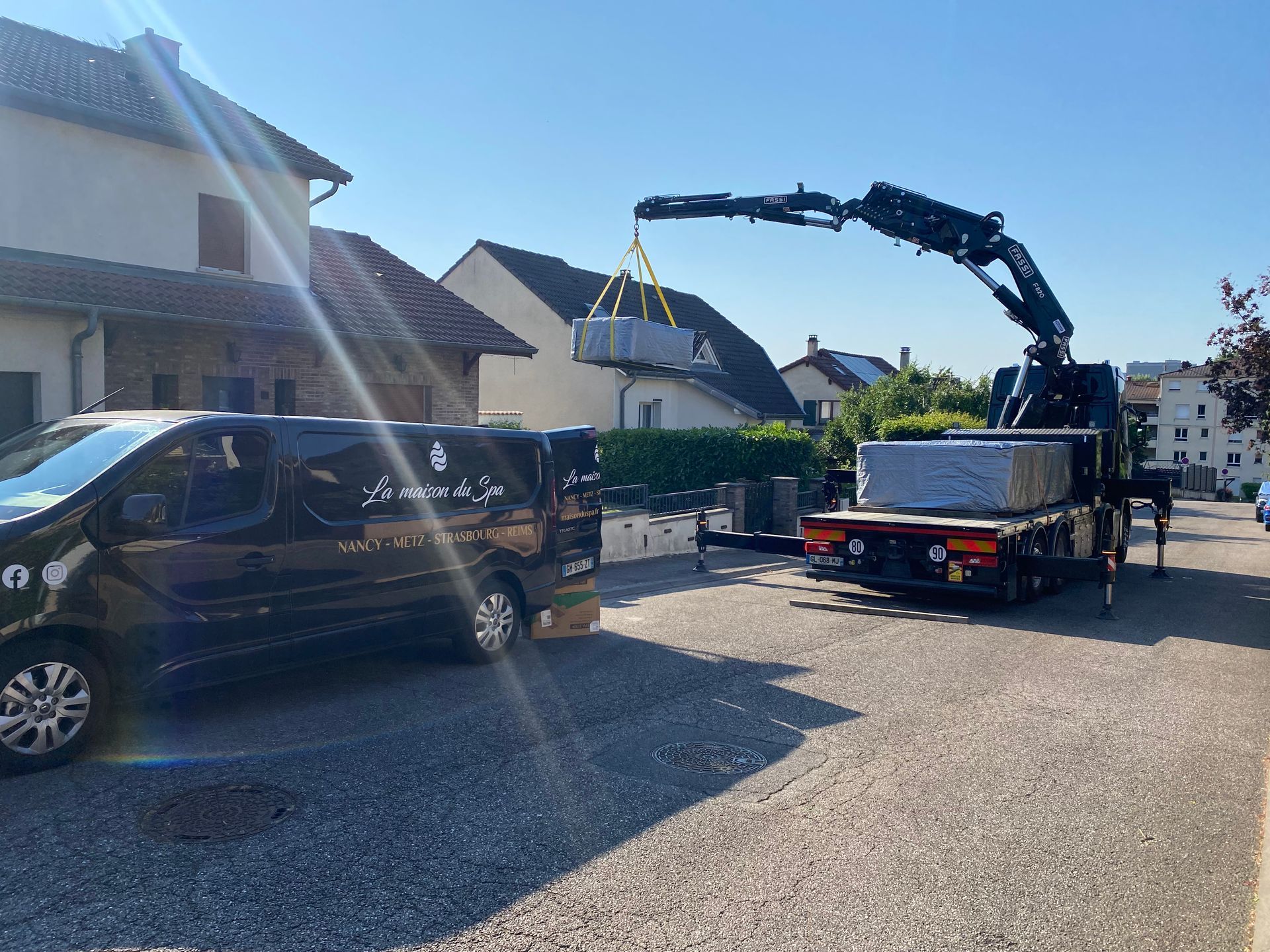 Un camion avec une grue attachée transporte une boîte.