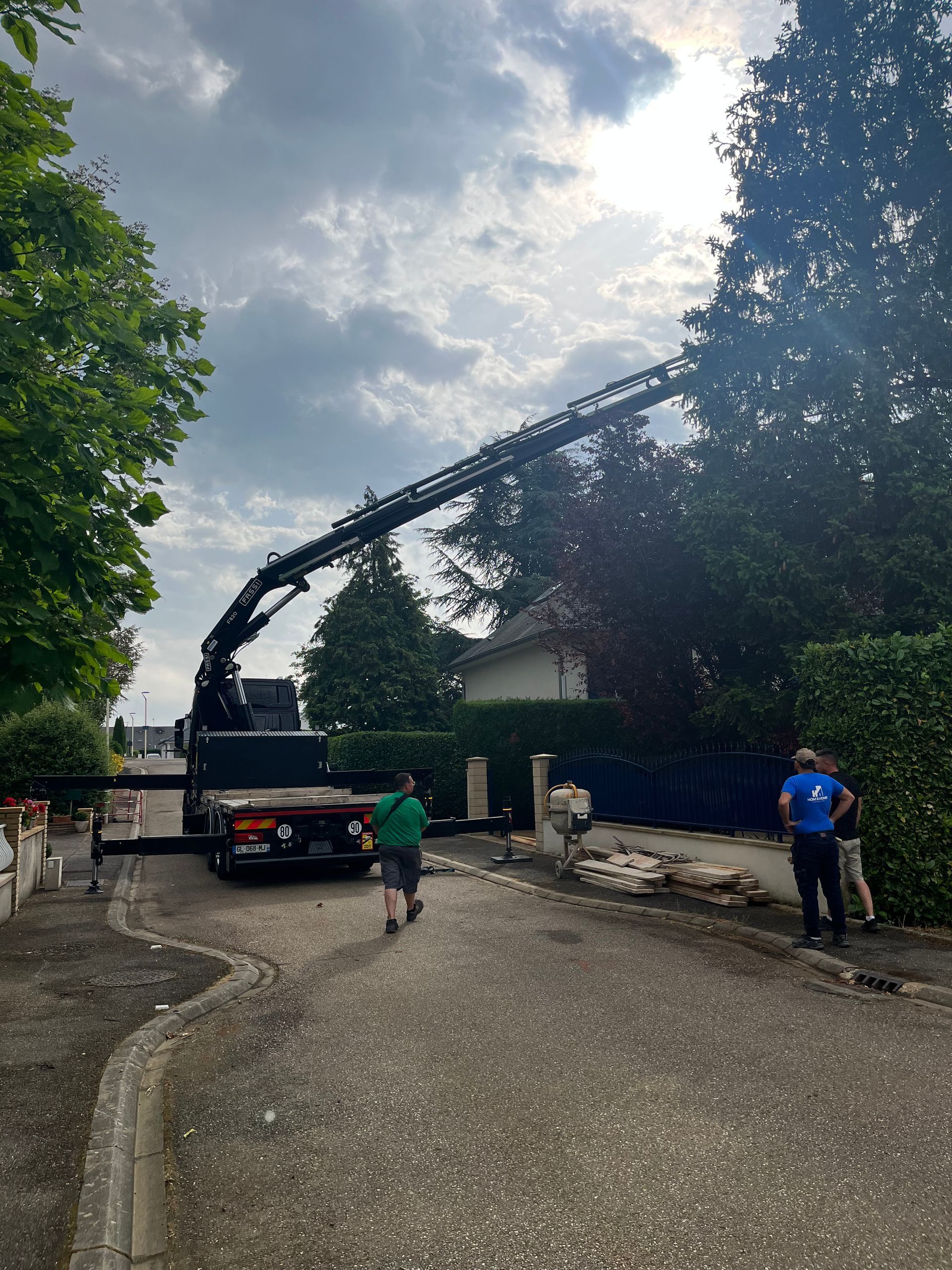 Un camion avec une grue dessus est garé sur le bord de la route.