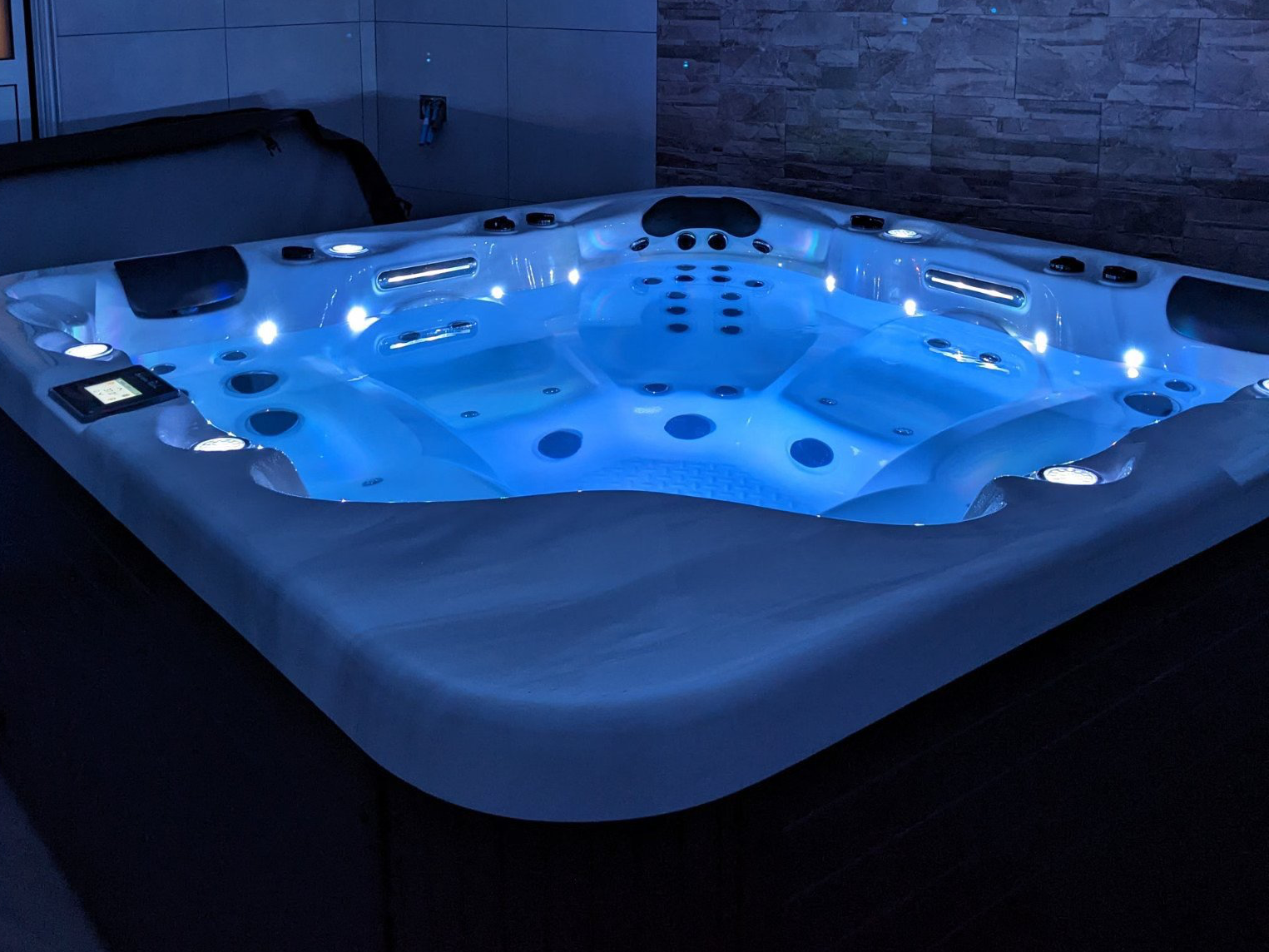 Un bain à remous est éclairé la nuit avec des lumières bleues