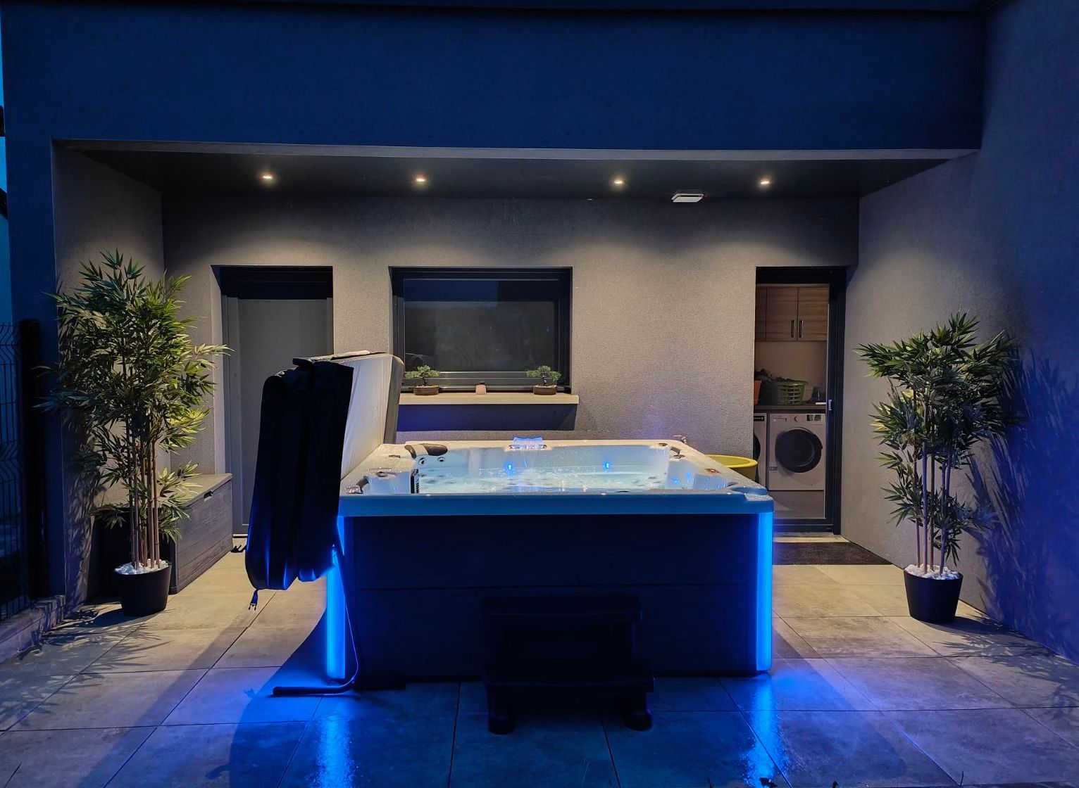 Un grand bain à remous est éclairé par des lumières bleues
