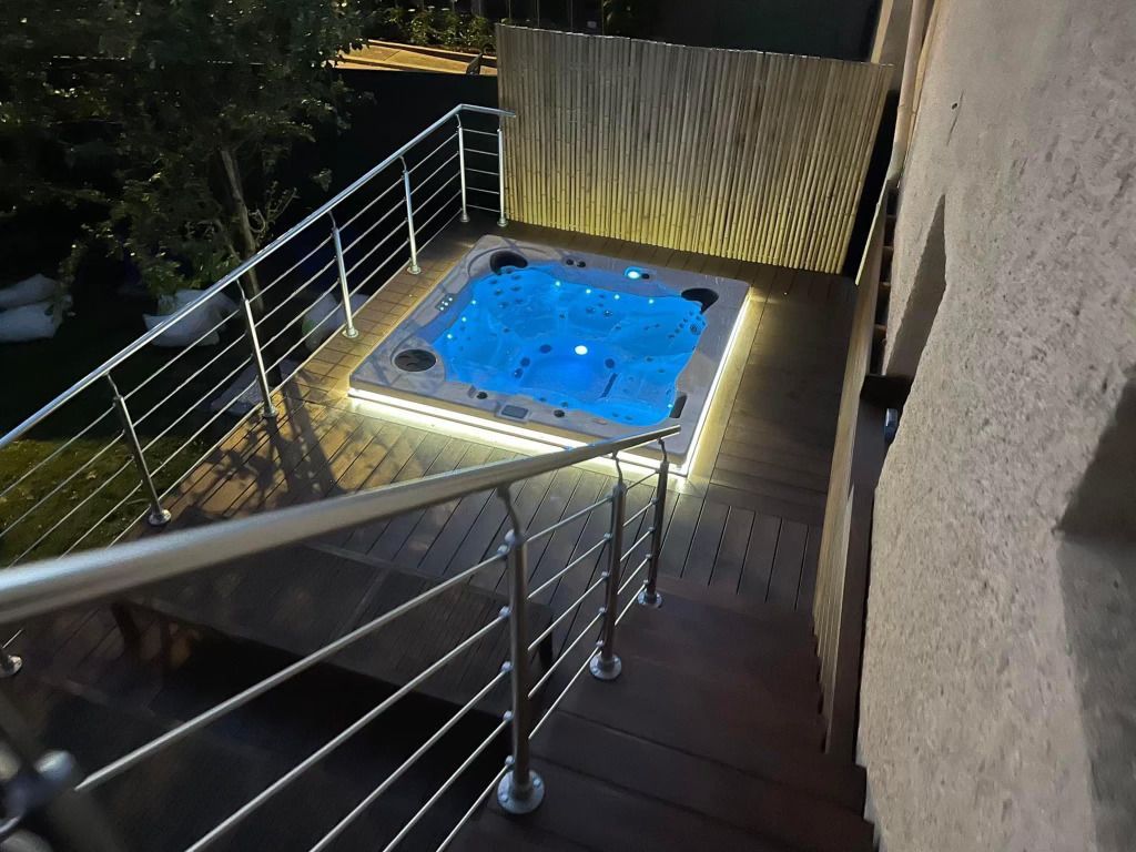 Un bain à remous sur une terrasse avec des escaliers qui y mènent