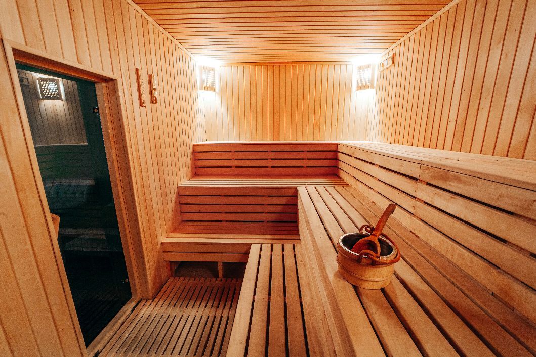 Un sauna en bois avec un seau et une cuillère sur les bancs.