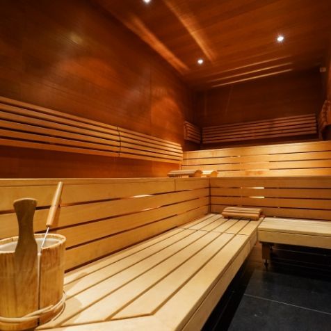 Un seau en bois repose sur un banc en bois dans un sauna