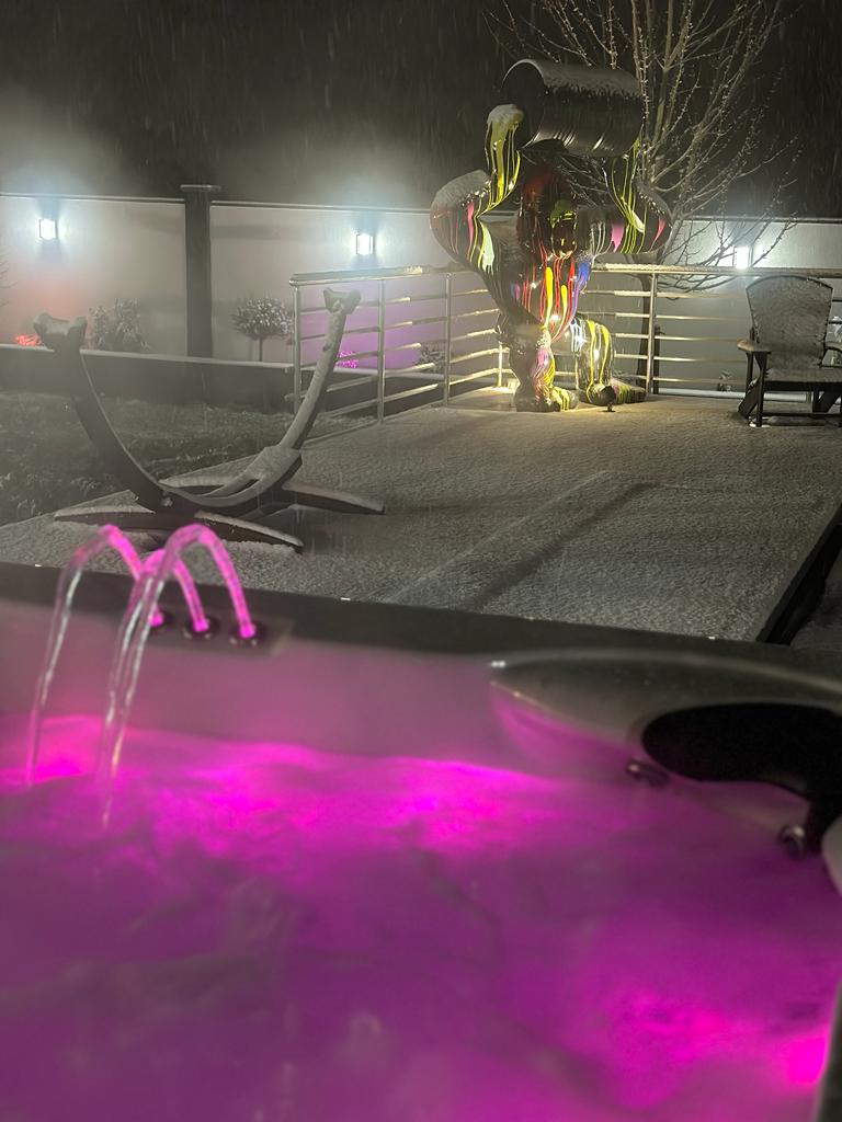 Un bain à remous est éclairé de lumières roses la nuit.