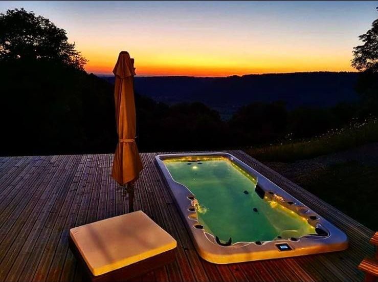 Une grande piscine sur une terrasse avec un coucher de soleil en arrière-plan
