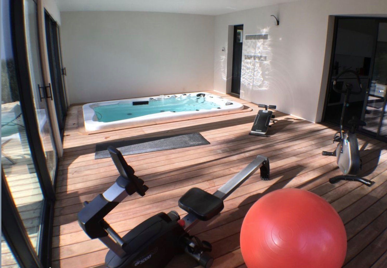 Une salle de sport avec un rameur et un ballon de Pilates