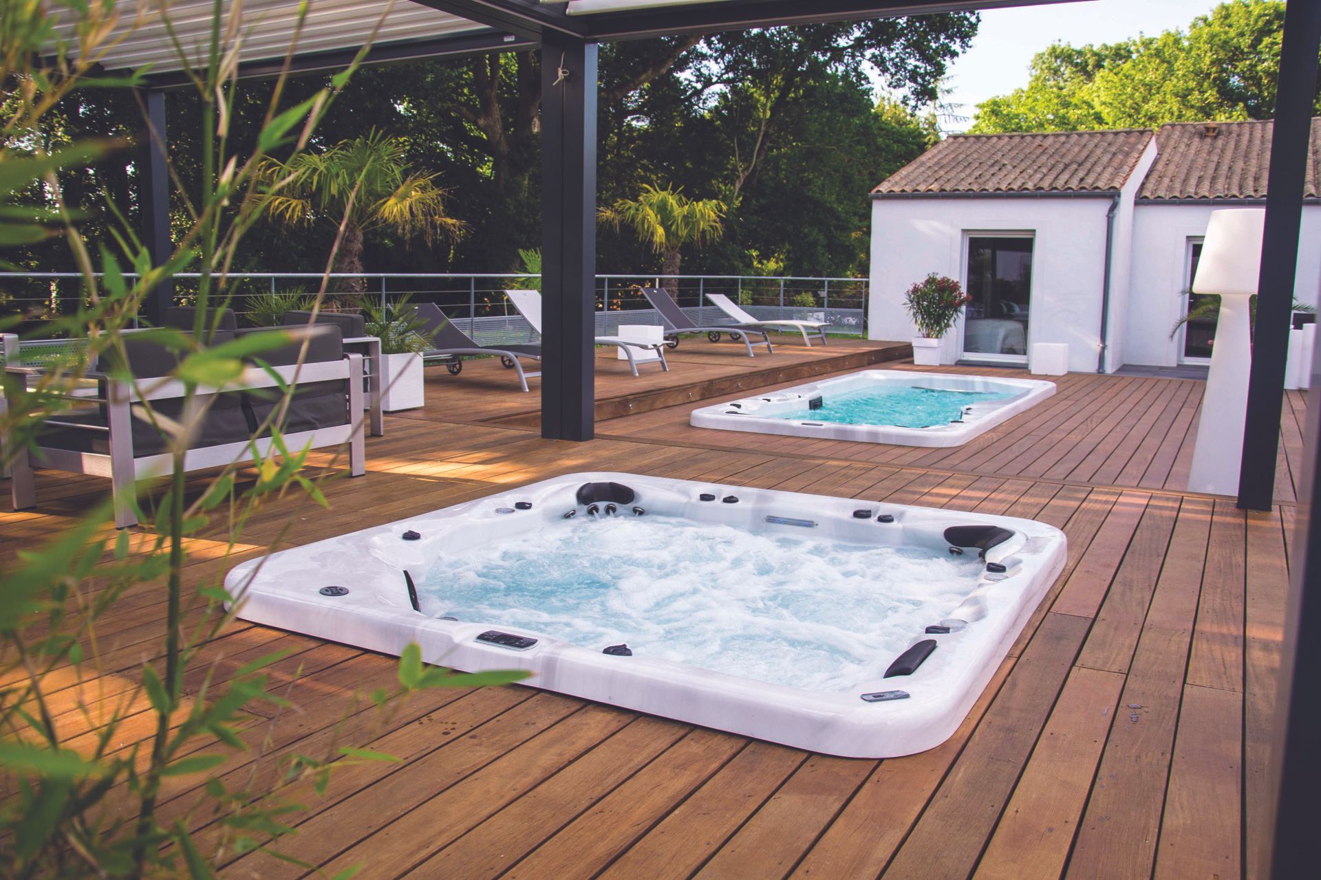 Deux jacuzzis sont installés sur une terrasse en bois