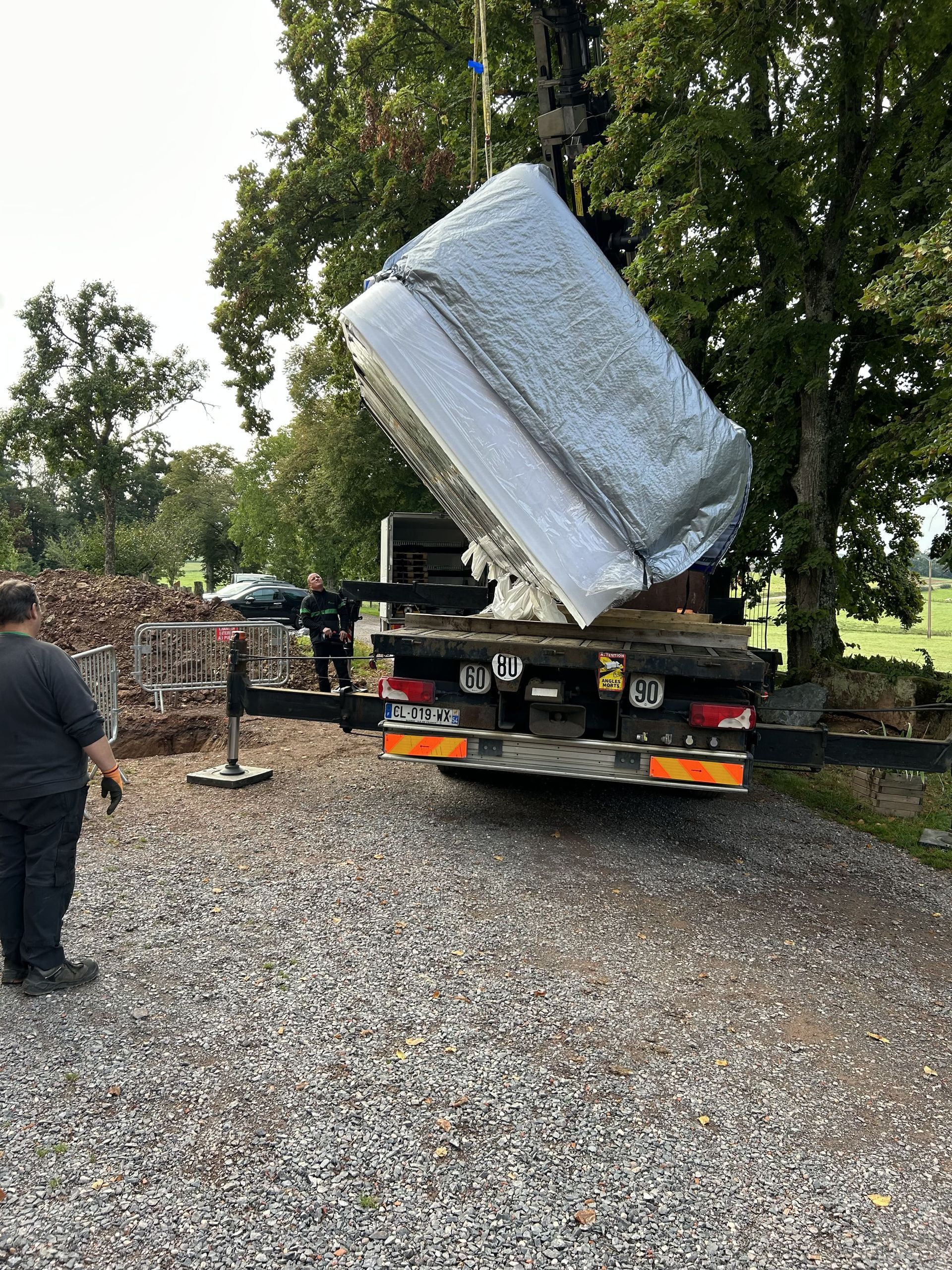 Un homme se tient à côté d'un camion qui transporte un matelas.