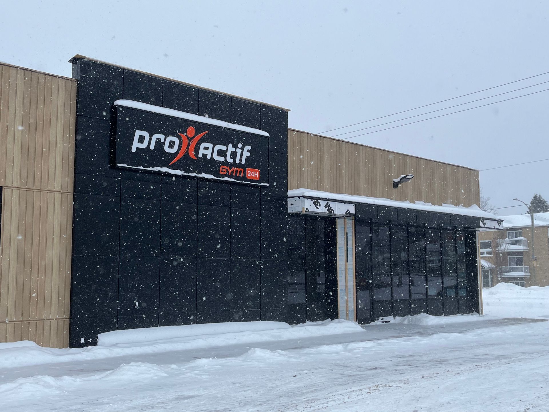 Façade enneigée avec une enseigne « produit » sur un bâtiment moderne