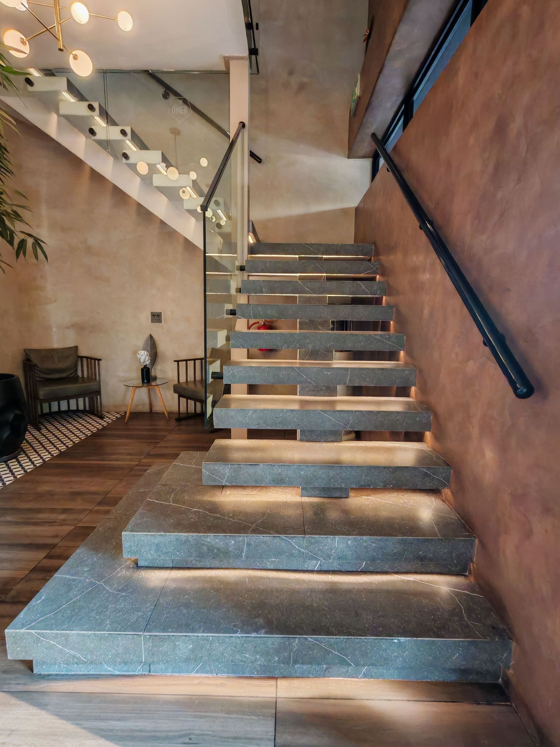 Floating concrete staircase with glass railing in a modern interior