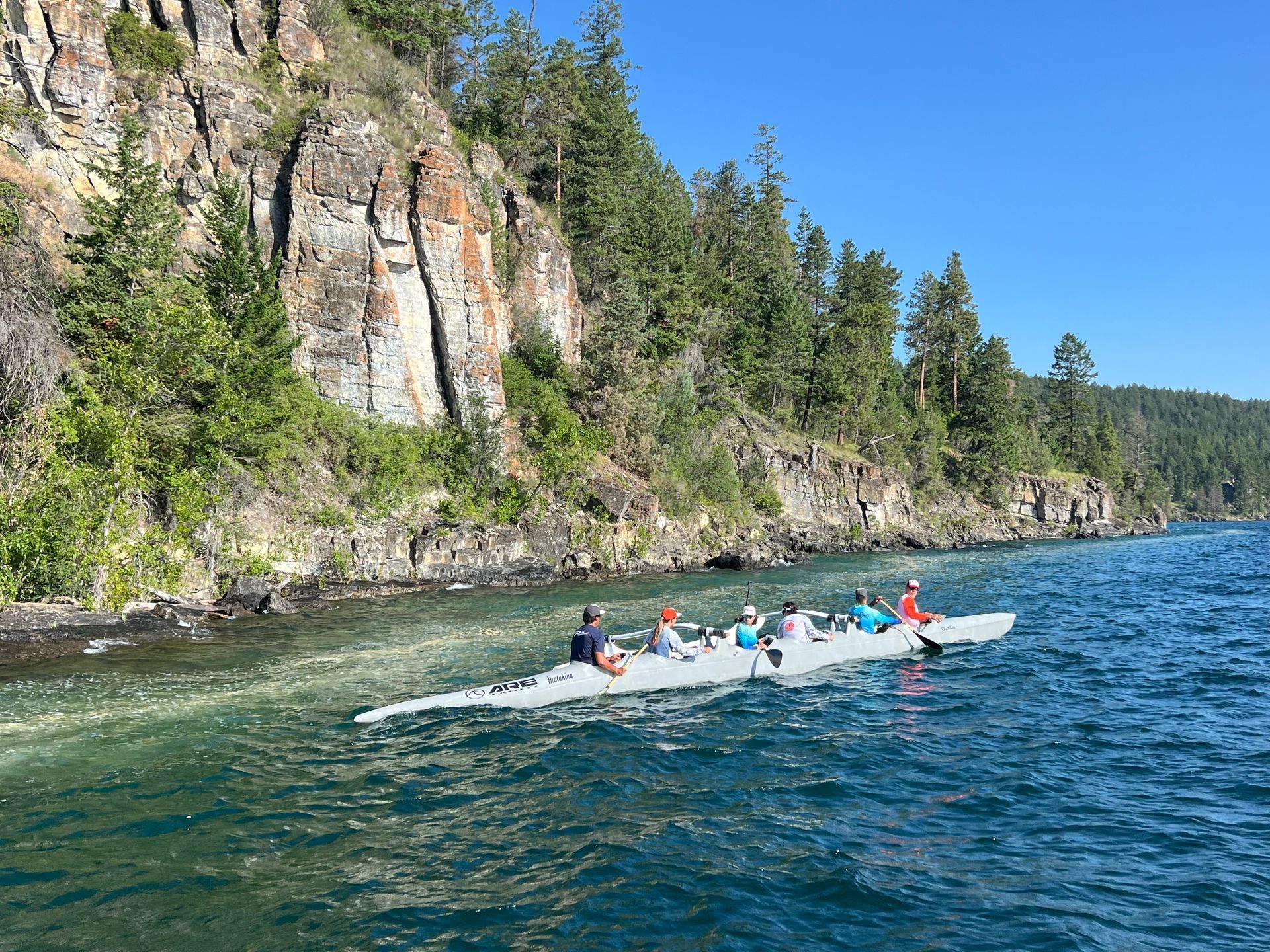 A group of people are rowing a boat on a lake.
