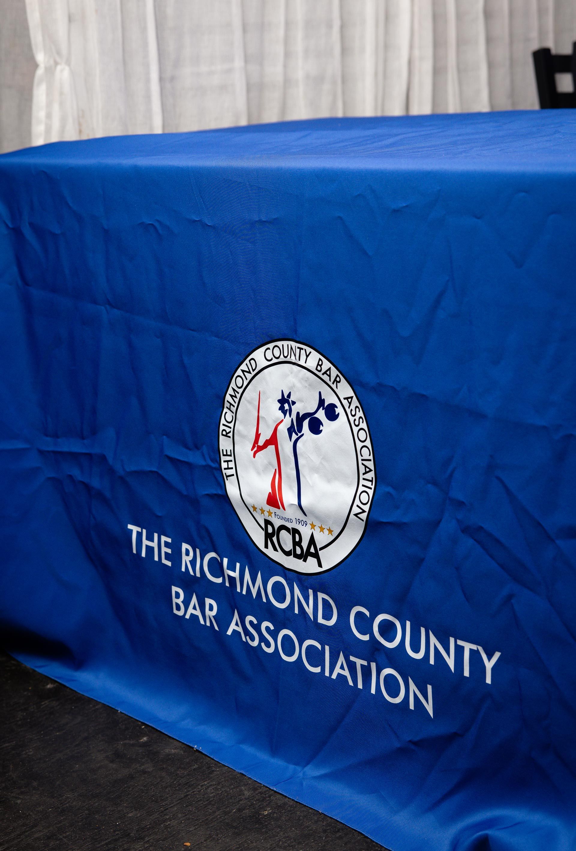 Blue tablecloth with The Richmond County Bar Association logo and text on a table