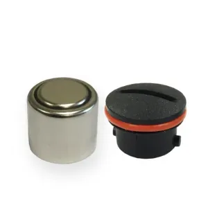 A small metal object next to a small black object on a white background.