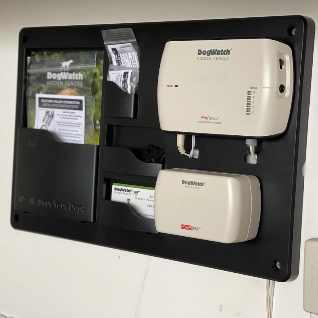 A dog watch device is hanging on a wall