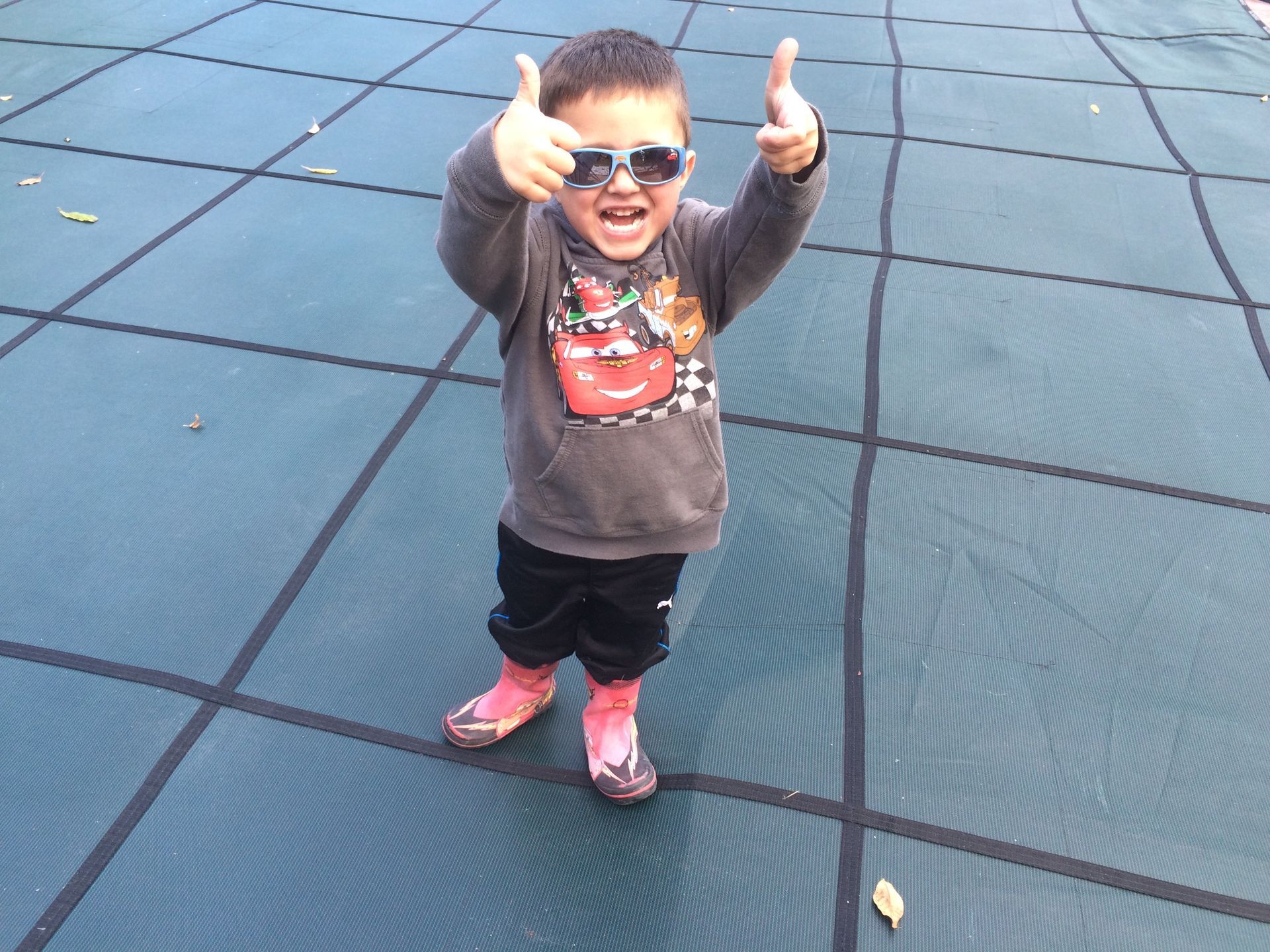 Kid standing on pool cover