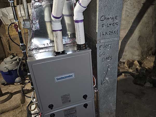 Gray utility box with white pipes and wiring in a basement or unfinished utility area