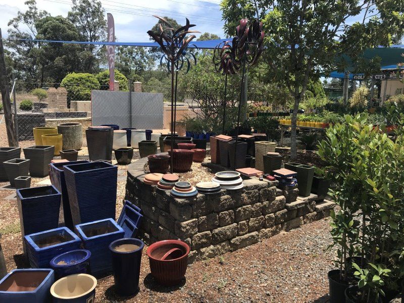 A Bunch of Pots Are Sitting on the Ground in a Garden— Golden City Brick & Landscape in Gympie, QLD