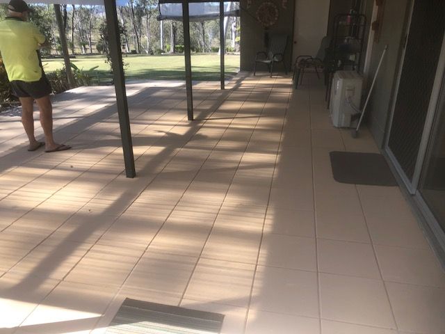 A Wooden Fence Surrounds a Concrete Walkway Next to a Gravel Driveway — Golden City Brick & Landscape in Gympie, QLD