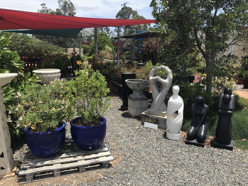 A Garden Filled With Lots of Potted Plants and Statues — Golden City Brick & Landscape in Gympie, QLD