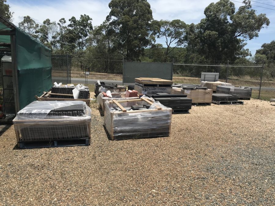 A Lot of Crates Are Sitting on the Ground in a Gravel Area — Golden City Brick & Landscape in Gympie, QLD