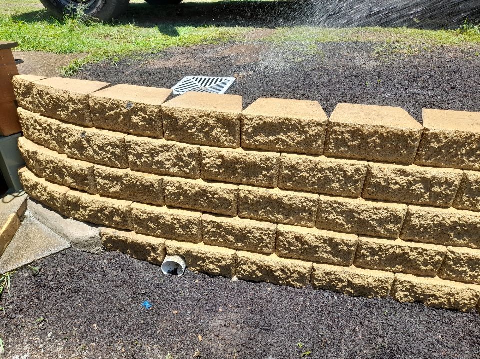 A Garden With Lots of Potted Plants and a Wooden Fence — Golden City Brick & Landscape in Gympie, QLD