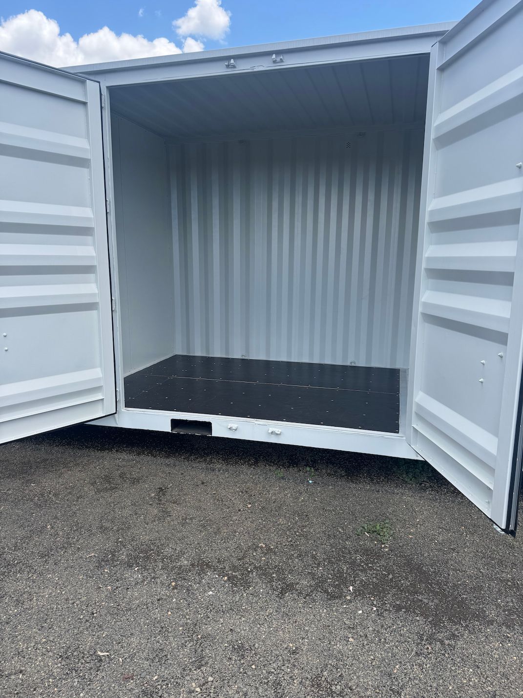 An Open White Storage Unit Sitting Outdoors on Gravel — King Street Storage Emerald in Emerald, QLD