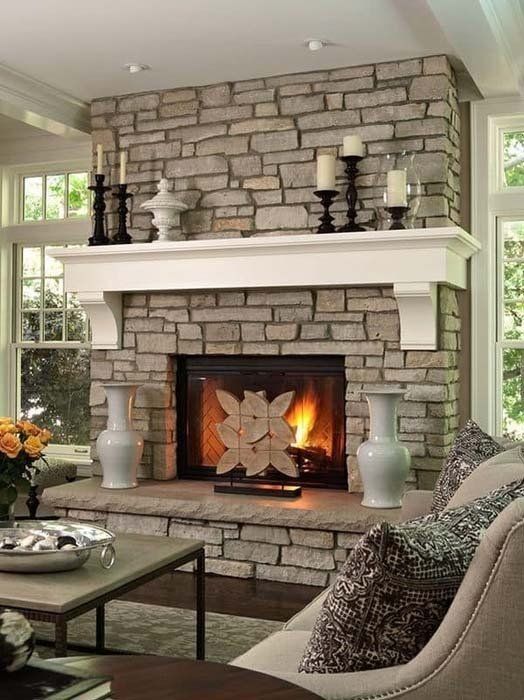 A living room with a fireplace and candles on the mantle