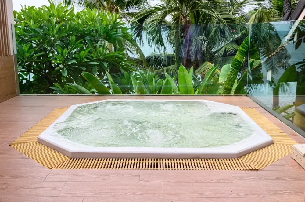 A White Hot Tub With Bubbling Water Sits on a Wooden Deck — Sun Cool Pools & Spas in Hervey Bay, QLD