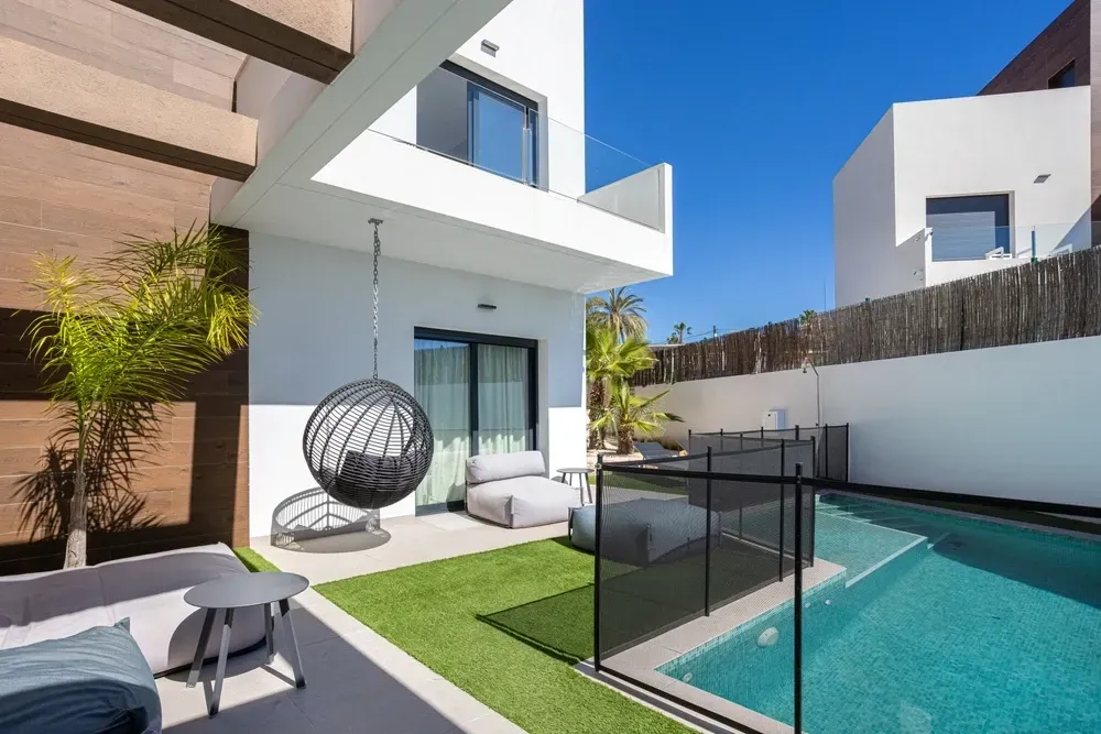 A Sunny Backyard With a Pool and Artificial Grass — Sun Cool Pools & Spas in Maryborough, QLD 