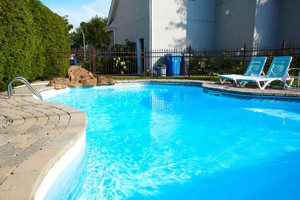 A Sunny Backyard Pool With Blue Water — Sun Cool Pools & Spas in Maryborough, QLD