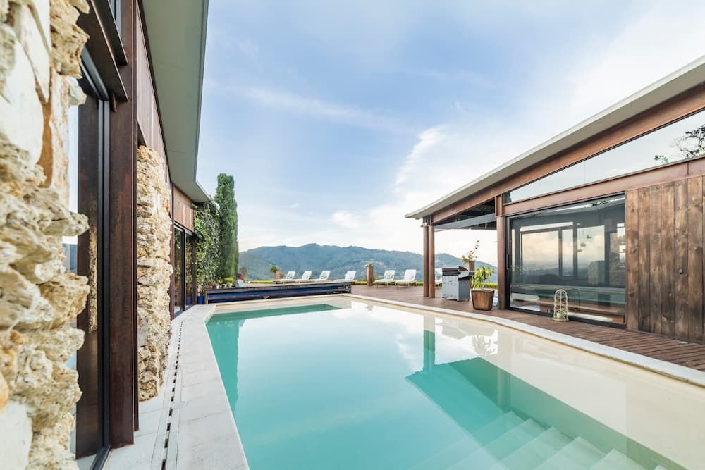 A Turquoise Infinity Pool on a Deck With Stone Walls — Sun Cool Pools & Spas in Maryborough, QLD